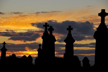 Gün batımında deniz kıyısında eski bir mezarlık.
