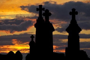 Gün batımında deniz kıyısında eski bir mezarlık.