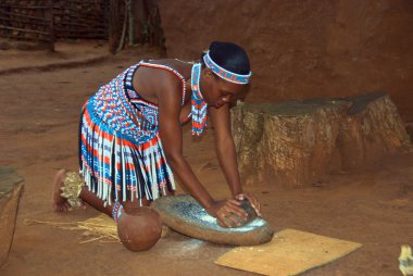 SAKALAND-NOVEMBER 27 :An unidentified young woman wears traditional Zulu clothing, made local beer with wheat on November 27, 2010 Shakaland Zulu Cultural Village, KwaZulu-Natal, South Africa