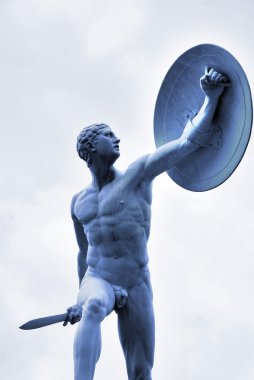 Gökyüzü arka planında antik savaşçı heykeli