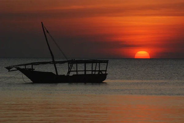 日没時に海に浮かぶ木のボート — ストック写真