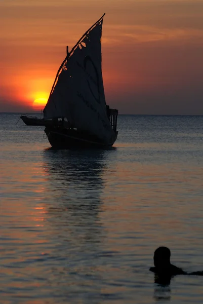 Wooden boat in sea at sunset
