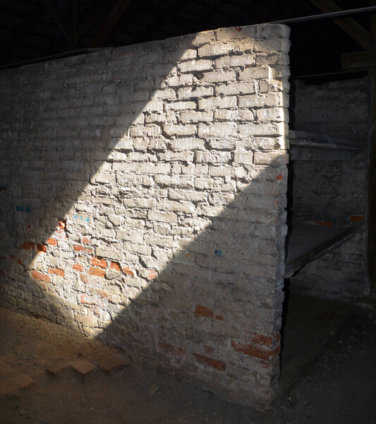 AUSCHWITZ BIRKENAU POLAND - 09 17 17: Sun ray in Auschwitz concentration camp inside barrack wall of German Nazi concentration camps and extermination camps built and operated by the Third Reich.