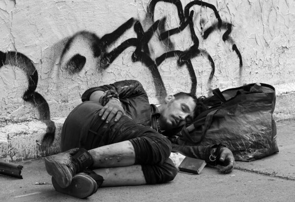 MONTREAL QUEBEC CANADA - 08 12 2021: Young homeless lying down on the sidewalk. Though estimates range anywhere from 10,000 to 30,000 people in the city of Montreal have no fixed address