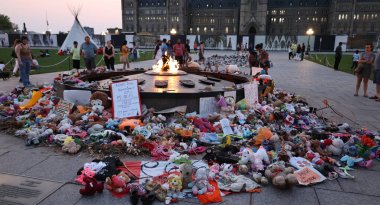 OTTAWA ONTARIO CANADA - 08 22 2021: Parliament Hill 'deki Centennial Flame çevresinde kalıntıları MÖ Kamloops, Kanada' da bir toplu mezarda bulunan yerli çocukların yaşamlarını onurlandırmak için düzenlenen anıt