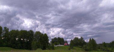 Fırtınadan önce gökyüzünün arka planında küçük bir ev. Mari El Cumhuriyeti, Rusya