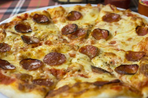 Pizza de pepperoni en la mesa con queso —  Fotos de Stock