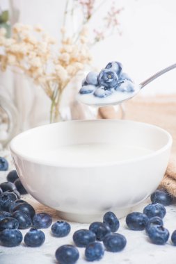Kaşık yoğurt ile üzerinde sulu ve taze yaban mersini