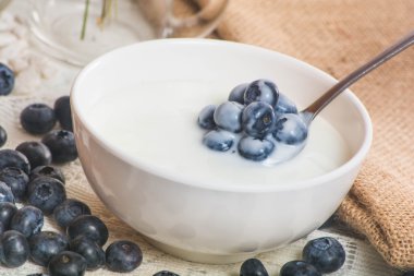 Kaşık yoğurt ile üzerinde sulu ve taze yaban mersini