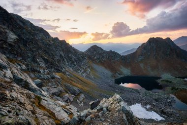 Bulutlarda gün batımında güzel dağlar, altın alp tarlaları, göller ve sıradağlar, seyahat ve dağ hayatı. Yüksek kalite fotoğraf