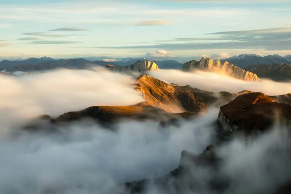 Montanhas em nevoeiro ao pôr-do-sol no outono. Paisagem com vale alpino, nuvens baixas, floresta, céu azul. Vista aérea — Fotografia de Stock