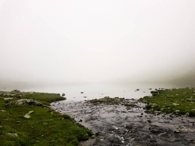 Kafkasya dağlarındaki, kristal su ve karlı dağlarla yeşil vadideki dağ manzarası. Yüksek kalite fotoğraf