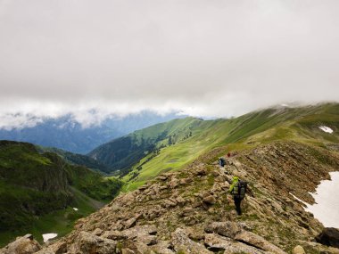 Sırt çantalı bir grup turist en tepeye çıkıyor. Sağlıklı yaşam tarzı kavramı, yürüyüş, yürüyüş maceraları. Yüksek kalite fotoğraf