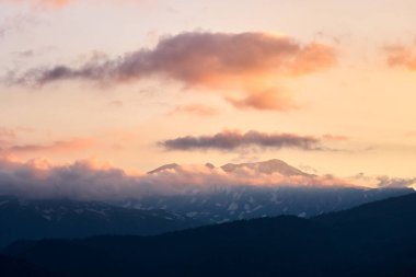 Gün batımında bulutlarda dağ zirveleri. Yüksek kalite fotoğraf