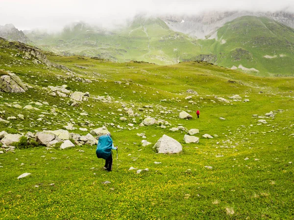 Turista Batohem Jde Travnatý Svah Pozadí Hor Mracích Koncept Zdravého — Stock fotografie