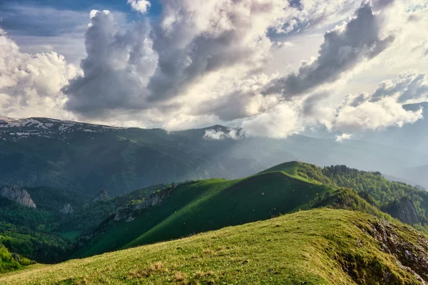 sun spots on meadow landscape with clouds. The formation and movement of clouds over the summer slopes of Adygea, Bolshoy Tkhach and the Caucasus Mountains