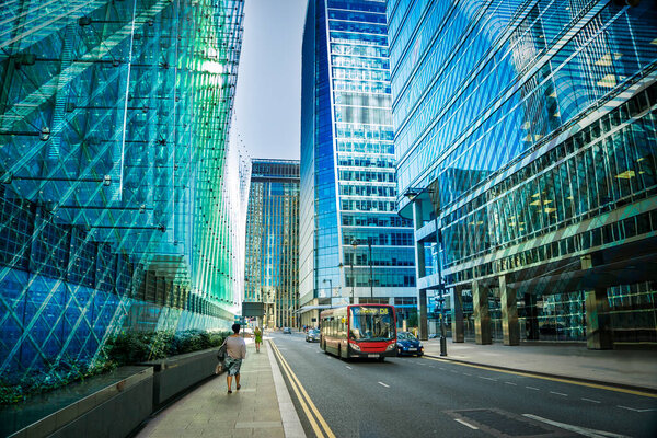 Office buildings, skyscrapers, road, bus, blue sky in the business district of London Canary Wharf, UK, no people. Can be used for websites, brochures, posters, printing and design.