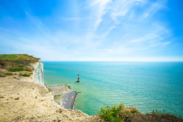 This is a scenic view by day on the blue sea, Beachy head Lighthouse, blue sky and white cliffs of the Seven Sisters, East Sussex, England, UK.Can be used for websites, brochures, posters, printing and design.