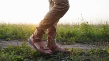 Bir adam çiçek tarlasında yürüyor. Mens ayakları orman boyunca yol boyunca yürüyorlar. Vahşi doğada bir adam. Kendini soyutlama. Karantinaya alın. Kapat.