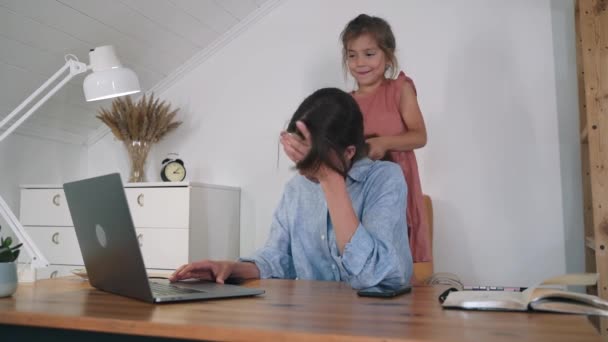 Çocuklu bir kadın dizüstü bilgisayarda çalışıyor. Kadın yorgundu ve gözlerini kapadı. Kız annesinin çalışmasını engelliyor. Yorgunluk. Stres yüzünden. Serbest çalışıyorum. Kendini soyutlama. Evde çalış. Ağır çekim. — Stok video