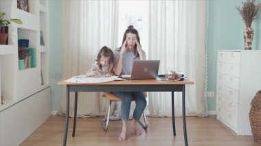 Evde, masada internetten çalışan bir kadın. Küçük bir kız annesinin çalışmasını engelliyor. Annem biraz ara verdi. Uzaktan kumanda. Aile bireysel izolasyonda. Merkez Ofis Mutlu çocukluk Karantina Salgını