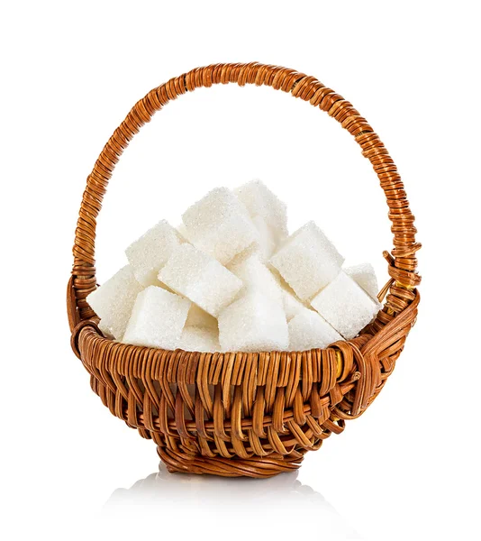 Cubes de sucre dans un panier en osier brun gros plan isolé sur un fond blanc — Photo