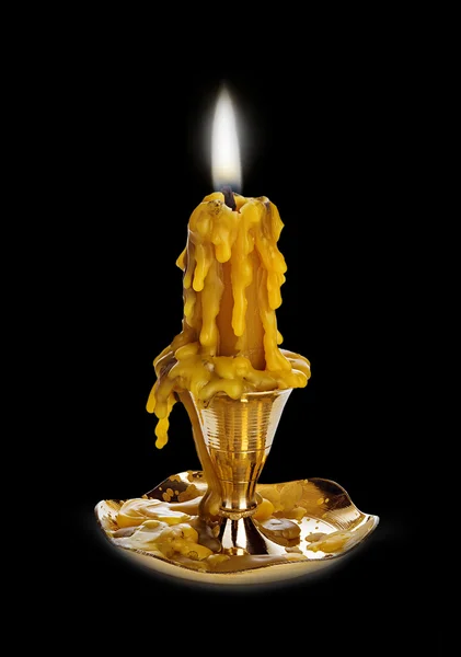 Burning vintage church candle wax  in old gold candlestick close-up on a brilliant black mirror background. — 스톡 사진