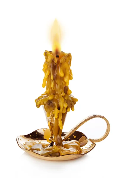 Burning vintage church candle wax  in old gold candlestick isolated on white background. — Stok fotoğraf