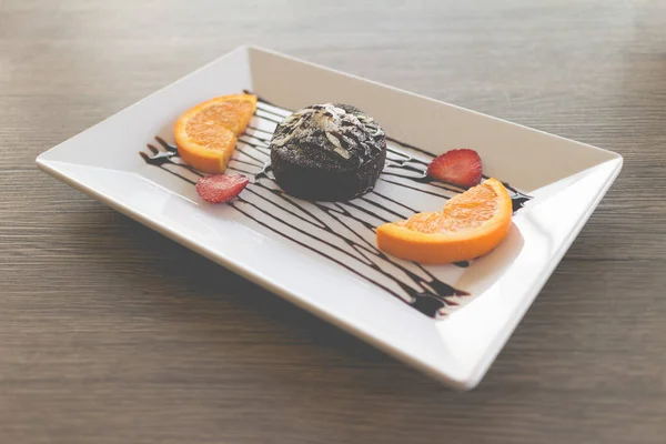 chocolate cake or chocolate lava cake with fresh fruit and coffee