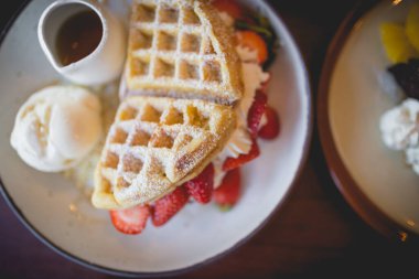 Vanilyalı krep çölü, taze çilek ve bal şurubu.