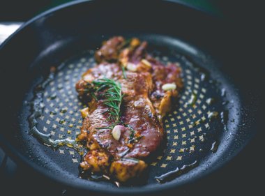 Biberiyeli biftek, sarımsak, tuz ve biber demir tavada.