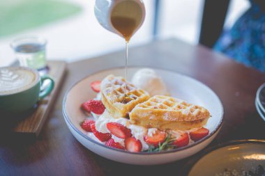 Vanilyalı krep çölü, taze çilek ve bal şurubu.