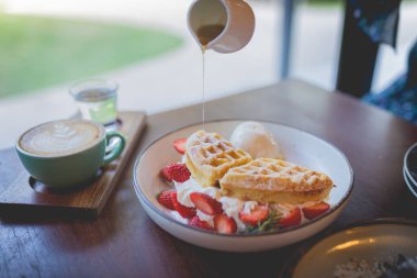 Vanilyalı krep çölü, taze çilek ve bal şurubu.