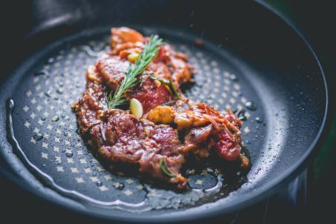 Biberiyeli biftek, sarımsak, tuz ve biber demir tavada.