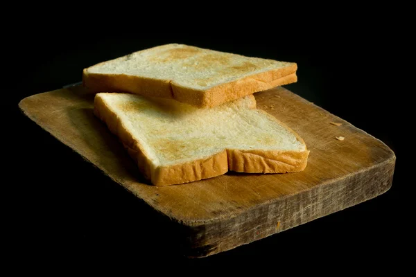 Tostadas en rodajas sobre bloque de madera picado —  Fotos de Stock