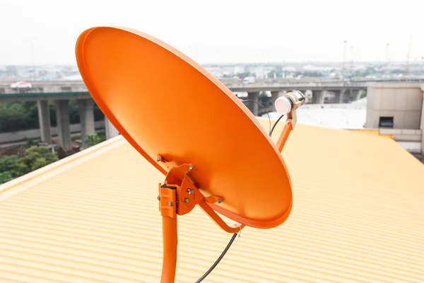 Antenne satellite orange et toit jaune — Photo