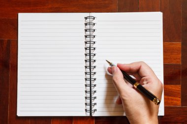 El yazmak üstünde defter kalem ile.