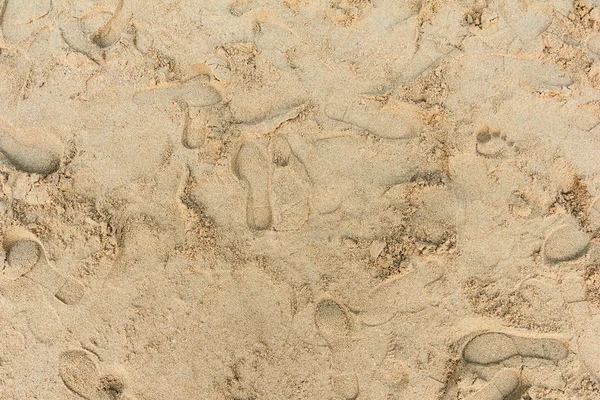 Foot print and shoe print on the sand.