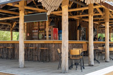 Sabahın erken saatlerinde sahilde boş bir bar. Barmenler ziyaretçileri bekliyor. Güzel ahşap bar.