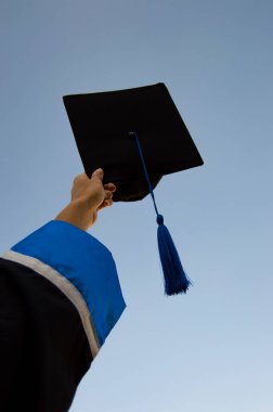 Üniversiteden mezun olmuş, yüksek lisans öğrencisi şapkalı, temiz mavi gökyüzü, seçici odaklı.