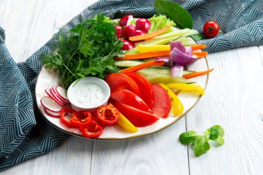 Tabakta taze sebzeler var. Hafif bir arkaplanda.