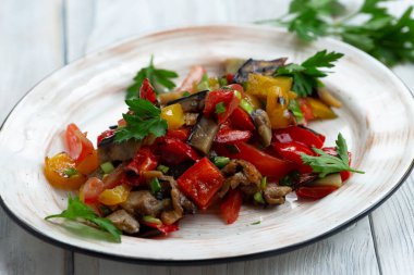 Hafif bir arka planda, tabakta kızarmış sebze.