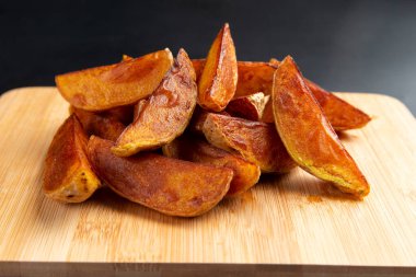 Tahtada patates parçaları. Karanlık bir arka planda