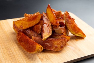 Tahtada patates parçaları. Karanlık bir arka planda