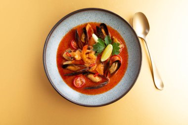 Sarı zemin üzerinde deniz ürünleri olan geleneksel çorba. Seçici odak