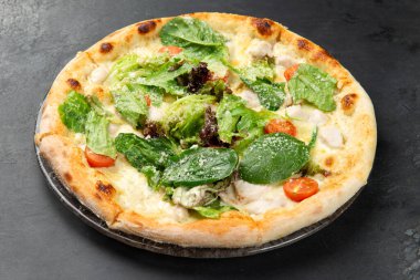 Tavuk, ot, domates ve peynirli pizza. koyu bir arkaplanda