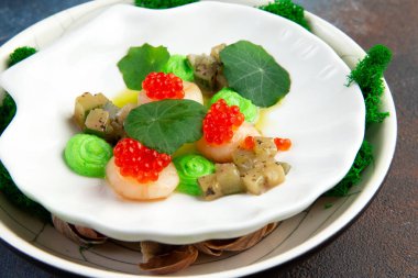 Havyarlı deniz tarakları, mikroyeşiller ve beyaz tabakta yeşil sos. Yakın plan..