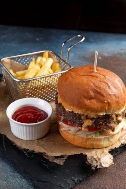 Taze lezzetli hamburger ve patatesler taşın üstünde. Seçici odak