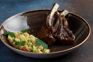 Karanlık bir arka planda, tabakta kuzu askısı. Seçici odak