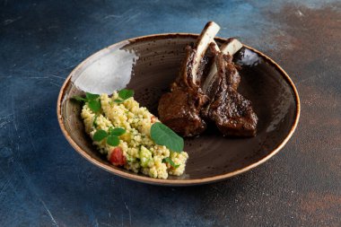 Karanlık bir arka planda, tabakta kuzu askısı. Seçici odak